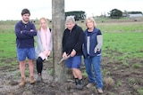 The Kenna family stand in a paddock on their farming property.