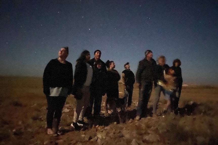 A group of people outside at night
