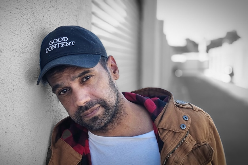 Darren Brady wearing a white shirt, a tan jacket and a black cap.