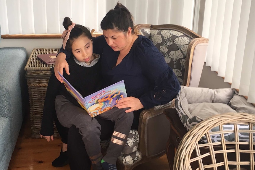 Jessica Armitstead is read to by her mother Natalie.