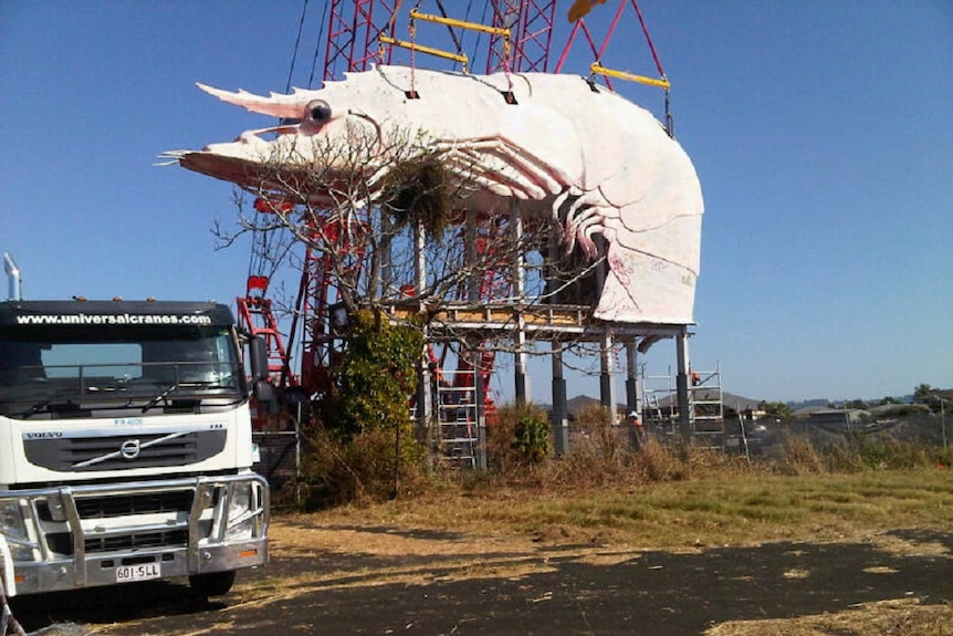 The big prawn without a tail being moved into its new position, ready for restoration.
