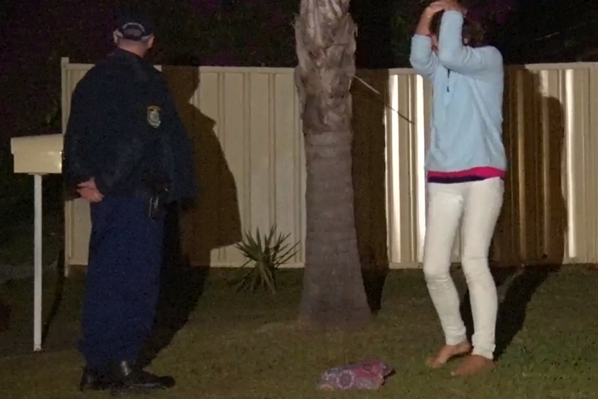 A woman becomes emotional at a home across the road from the crime scene