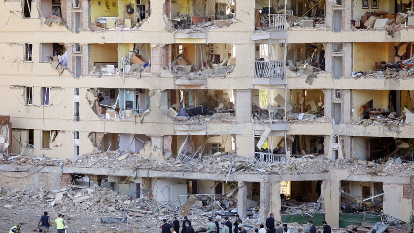 Spanish police walk in front of the gutted civil guard barracks