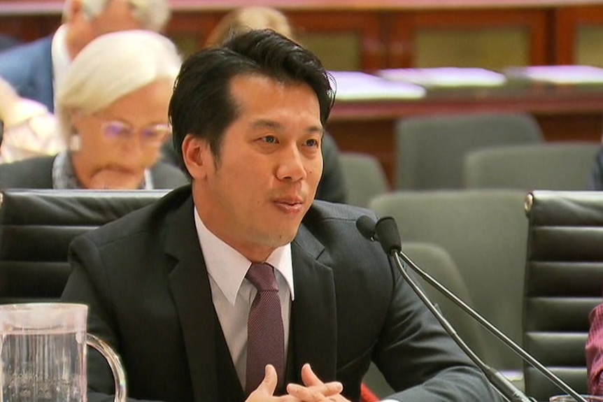 Alton Chen sits in front of a microphone.