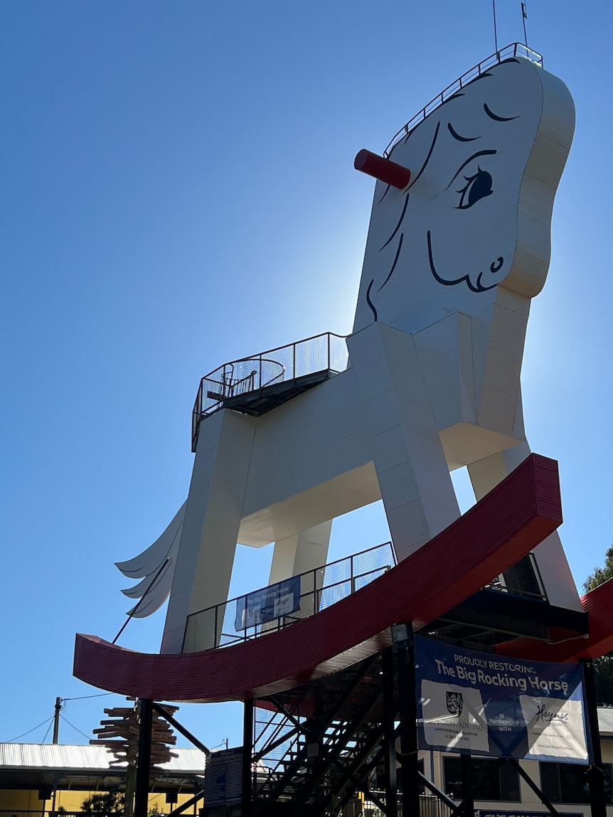 An 18-metre-tall rocking horse statue set against a blue sky.