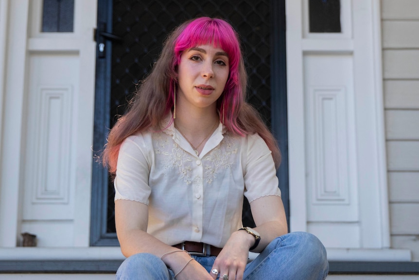 A woman sitting on a staircase outside.