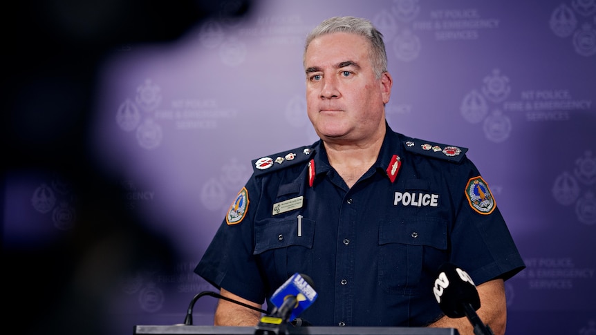 NT Police Commissioner Michael Murphy standing at a lectern, in front of a NT Police banner.