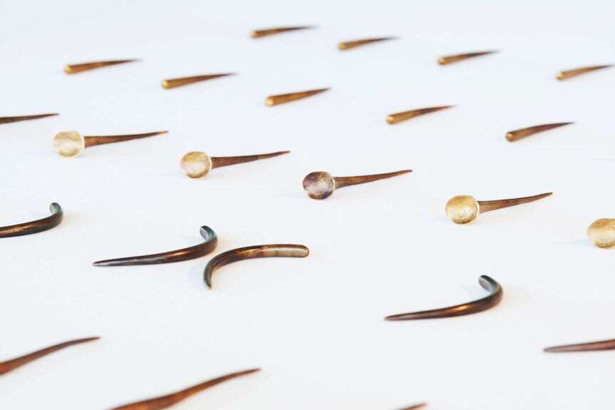 Bronze sculptures by Judy Watson, different shaped pins in a row