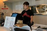 A man at a cash register in a restaurant