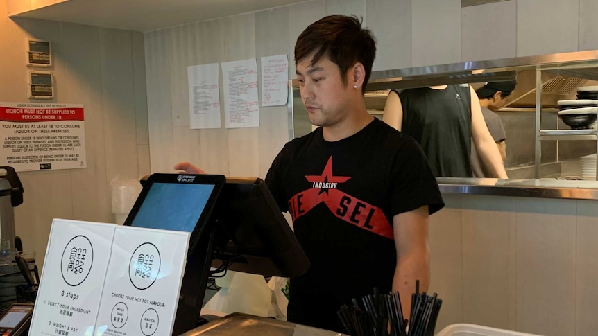 A man at a cash register in a restaurant