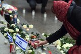 A woman places a candle at the memorial site in Berlin.