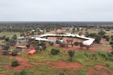 An aerial view of a rectangular structure, surrounded by red dirt.