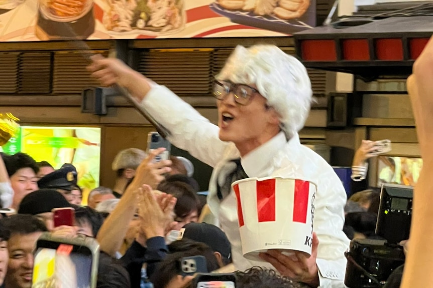 A Hanshin Tigers fan wearing Colonel Sanders costume and holding a KFC bucket