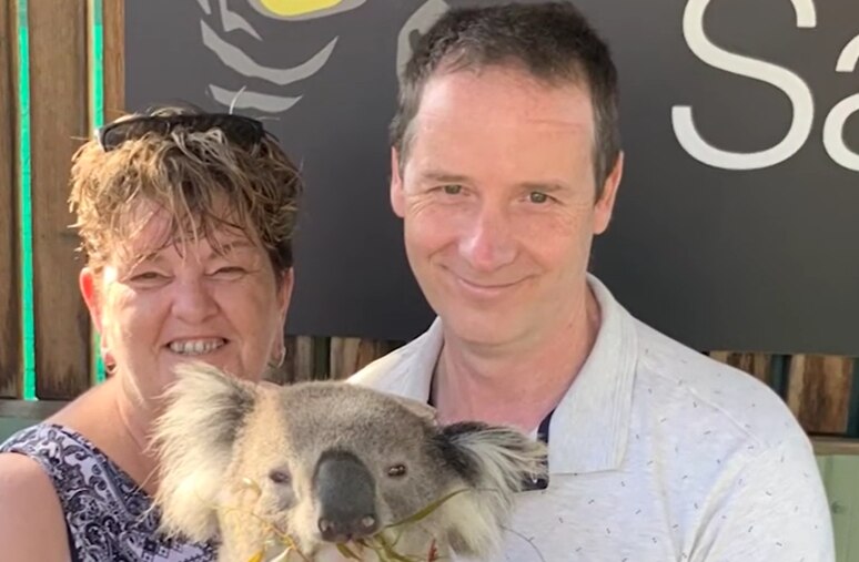 A man and a woman holding a koala.