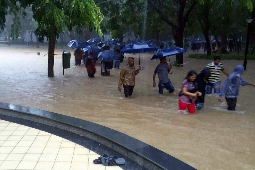 Employees trying to get to work during Indian monsoon