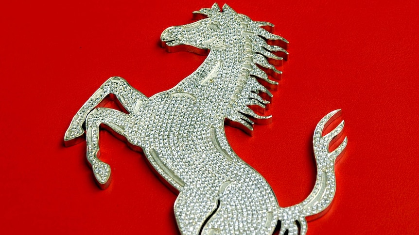 The diamond-encrusted Ferrari Prancing Horse logo on the cover of the Enzo Diamante edition book.