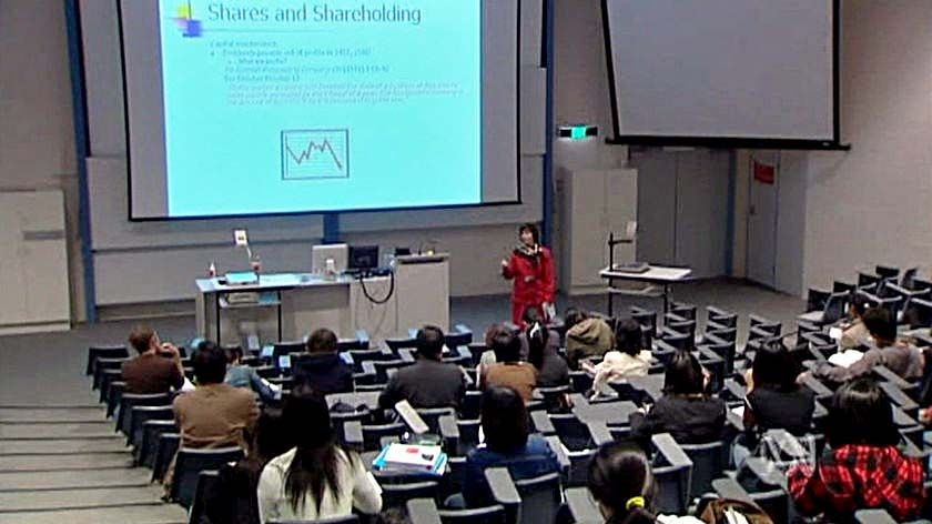 A university lecturer teaches a class of students.