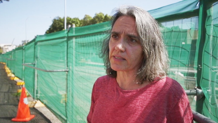 Kate Cotis stands in front of a fence