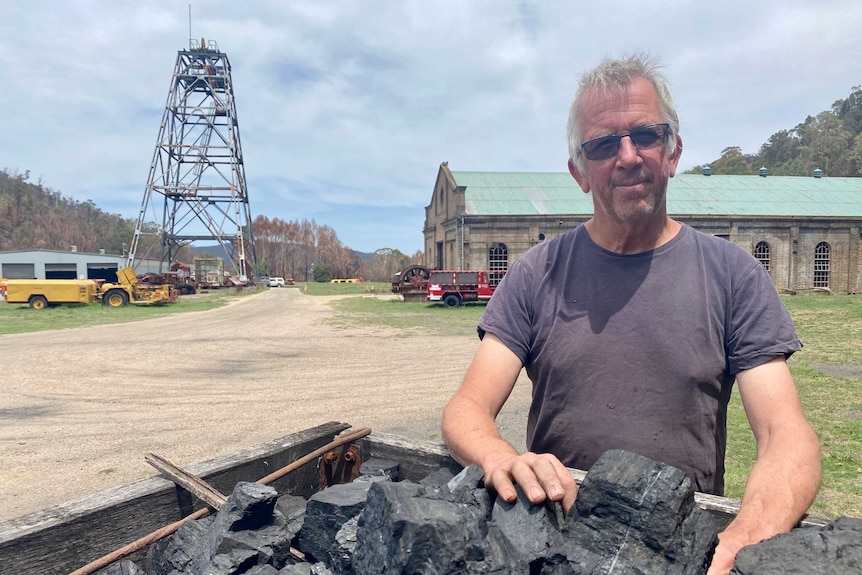 Phil Sparks, a blacksmith, stands in front of a bucket of coal.