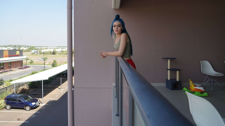 Blue haired young lady Angel Worthington on her balcony.