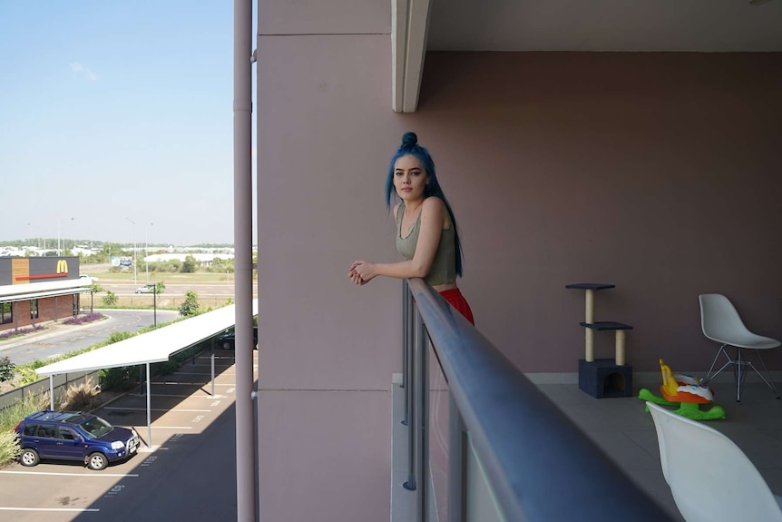 Blue haired young lady Angel Worthington on her balcony.