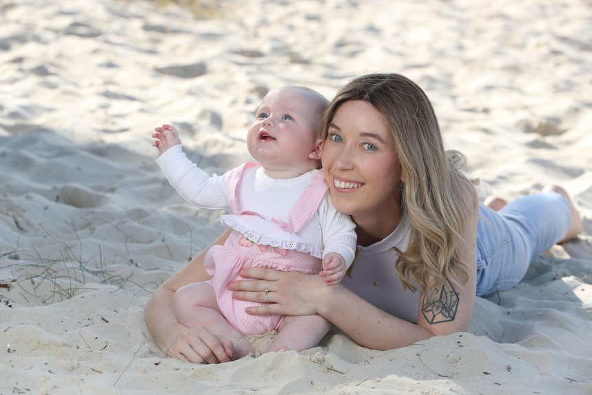 Sarah Shaddick with baby daughter Halle on the beach.
