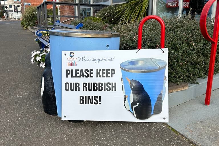 A poster of a bin covered in Penguins, calling for the bins to remain
