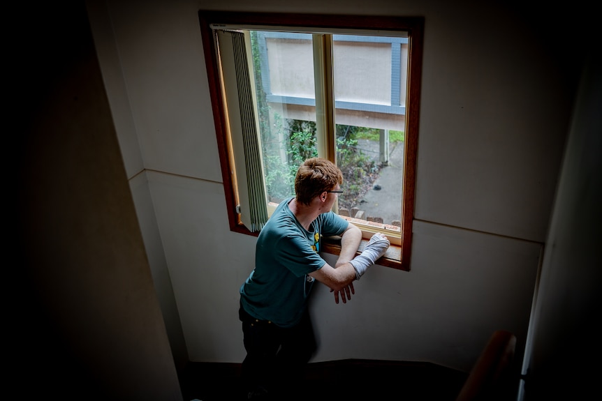 A young man standing at the window.