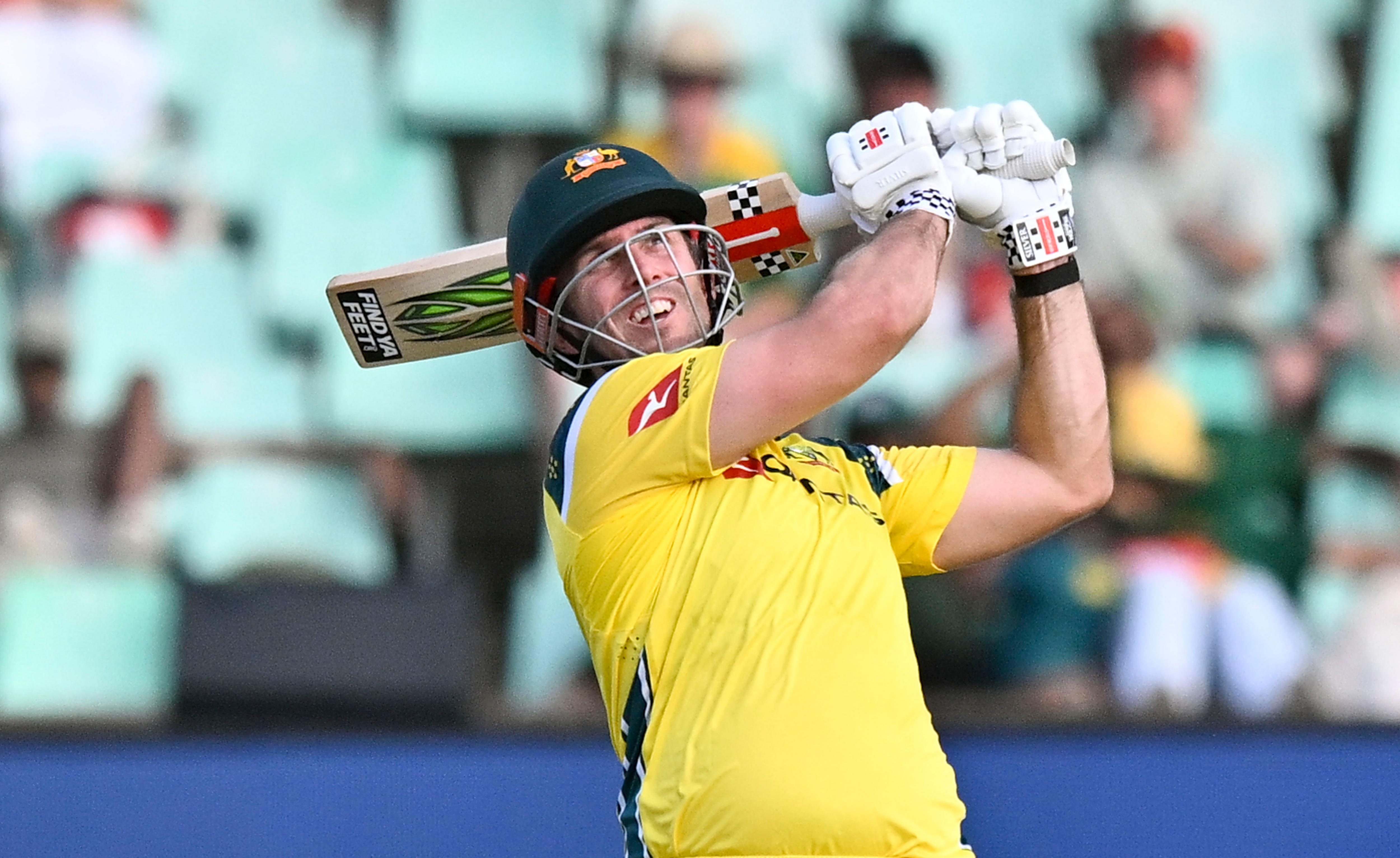 Mitchell Marsh swings a bat and watches the ball