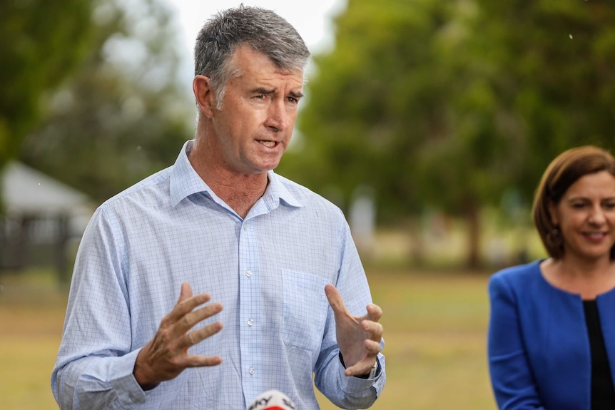 Man with grey hair and blue shirt speaking