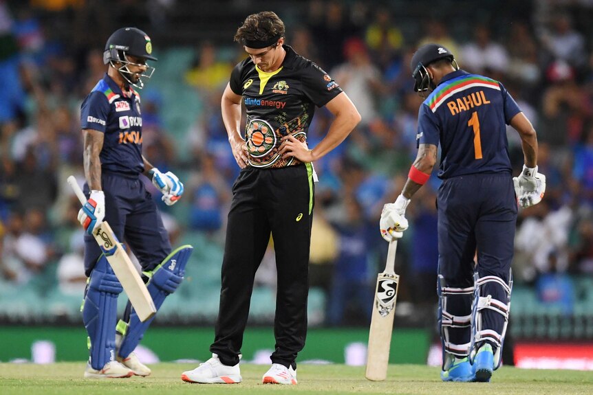 An Australian male bowler looks downcast after being hit for a boundary against India.