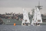 Small sailing boats in front of warship in Sydney