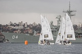 Small sailing boats in front of warship in Sydney