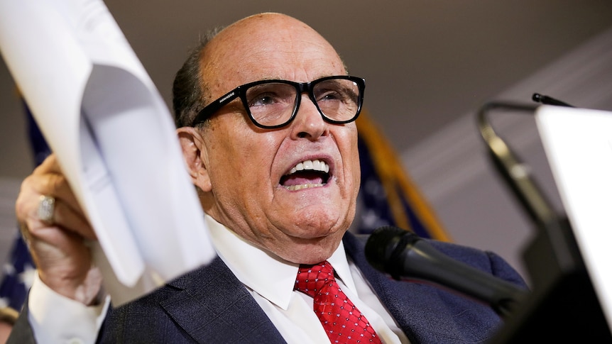 Former NYC mayor and Donald Trump's erstwhile personal attorney Rudy Giuliani gestures at a press conference in 2