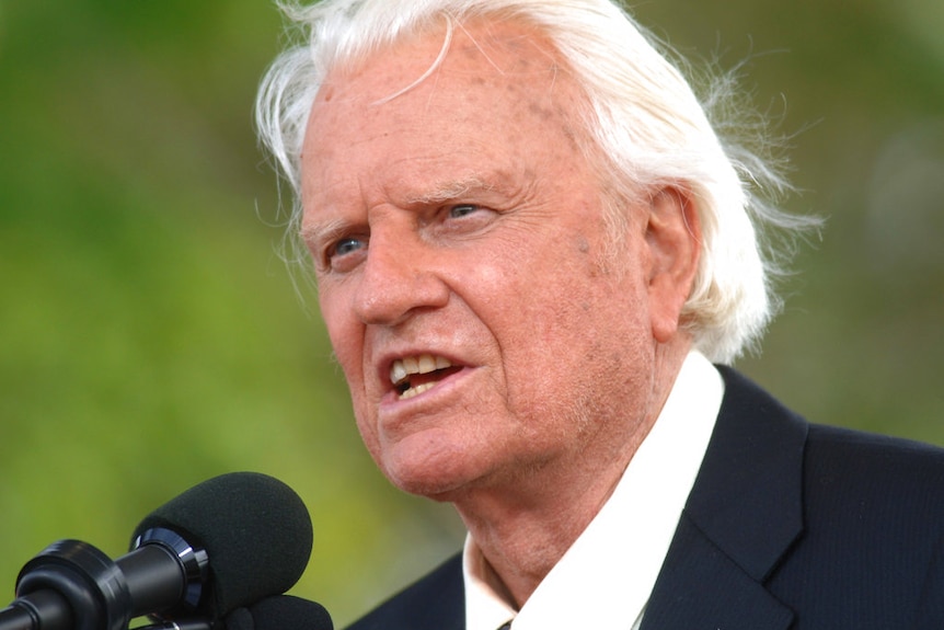 Head shot of Billy Graham speaking at microphone
