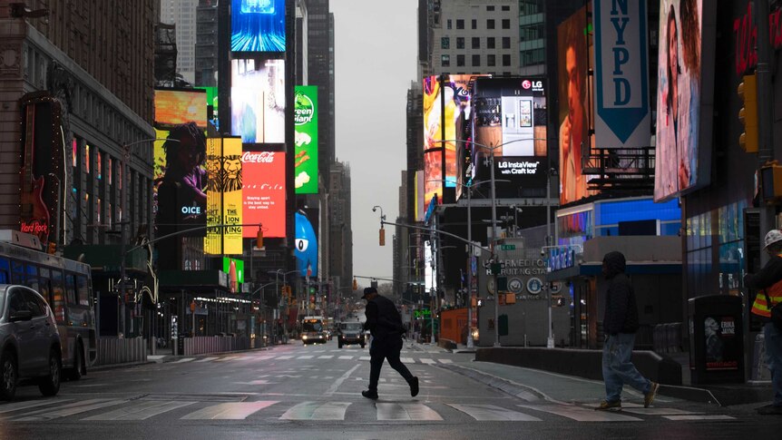A man walks through a nearly empty Times Square, which is usually very crowded on a weekday morning.
