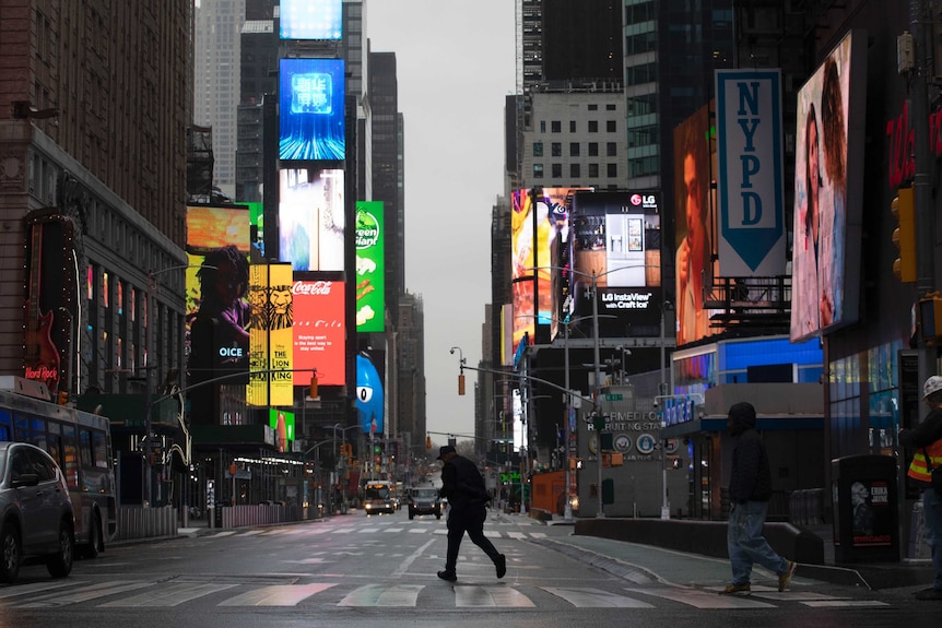 A man walks through a nearly empty Times Square, which is usually very crowded on a weekday morning.