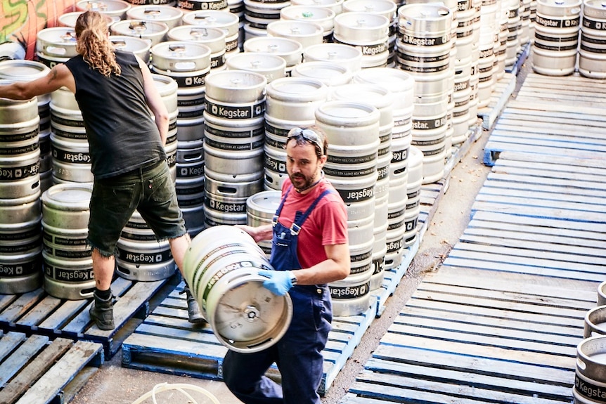 Tres hombres trabajando en una cervecería.