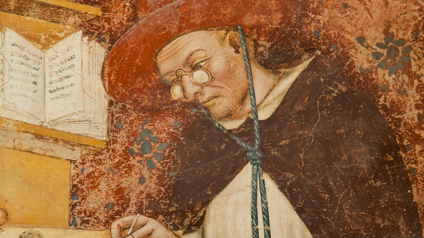 Old painting with peeling colour of man with circular, red hat holding quill and writing at a desk, while smiling.
