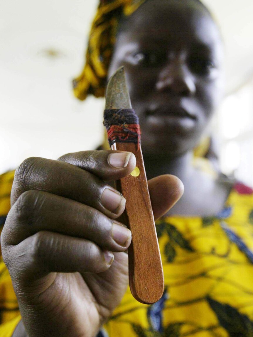 A woman who performs genital cutting holds the knife