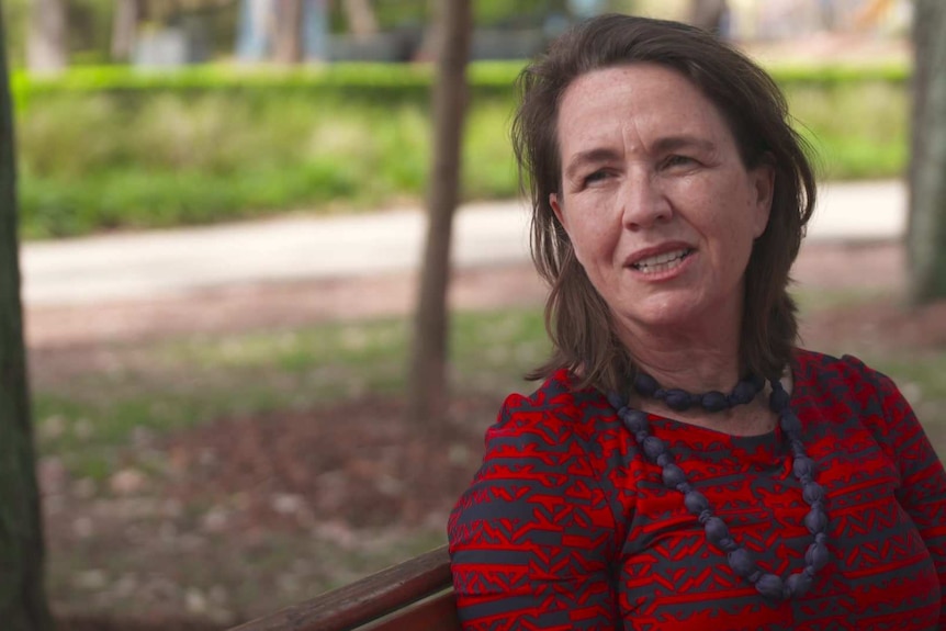 A woman sitting on a park bench.