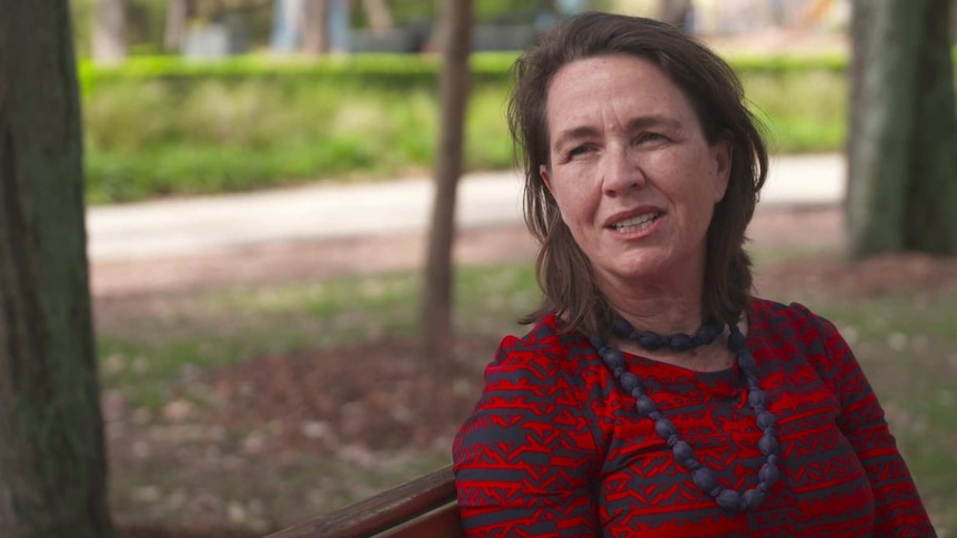 A woman sitting on a park bench.