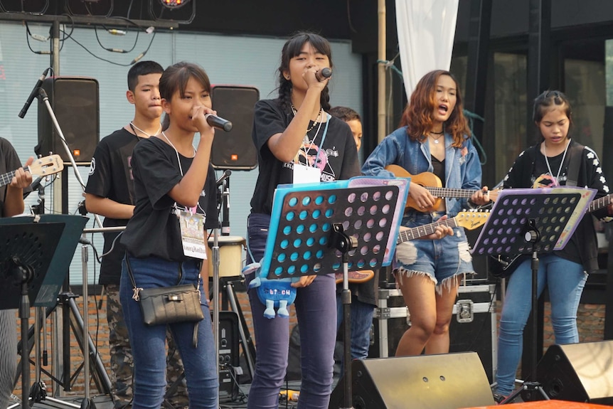 Thai teens sing on stage.