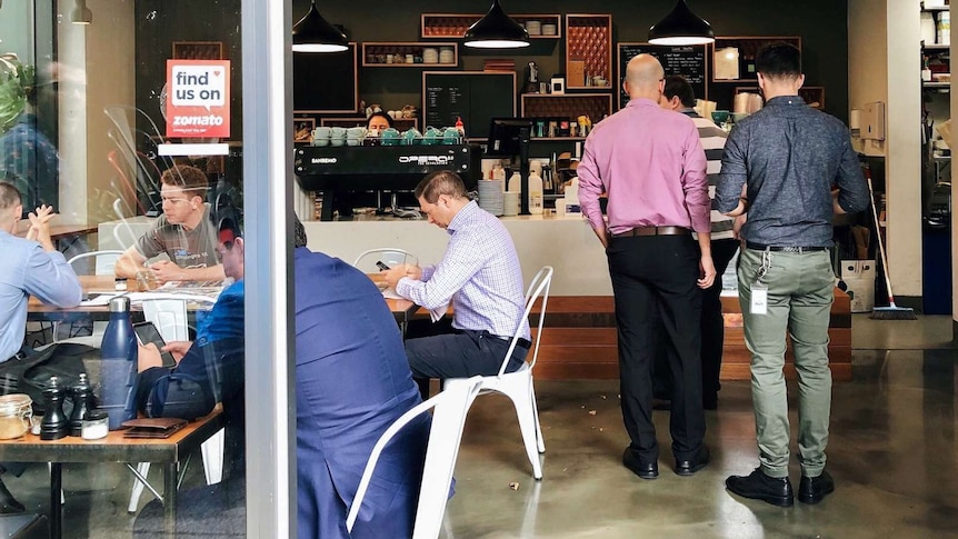 People waiting for coffee in a cafe.