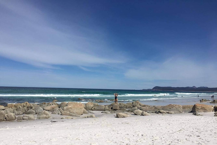 A girl stands on the white sand of Friendly Beaches on Tasmania's east coast.