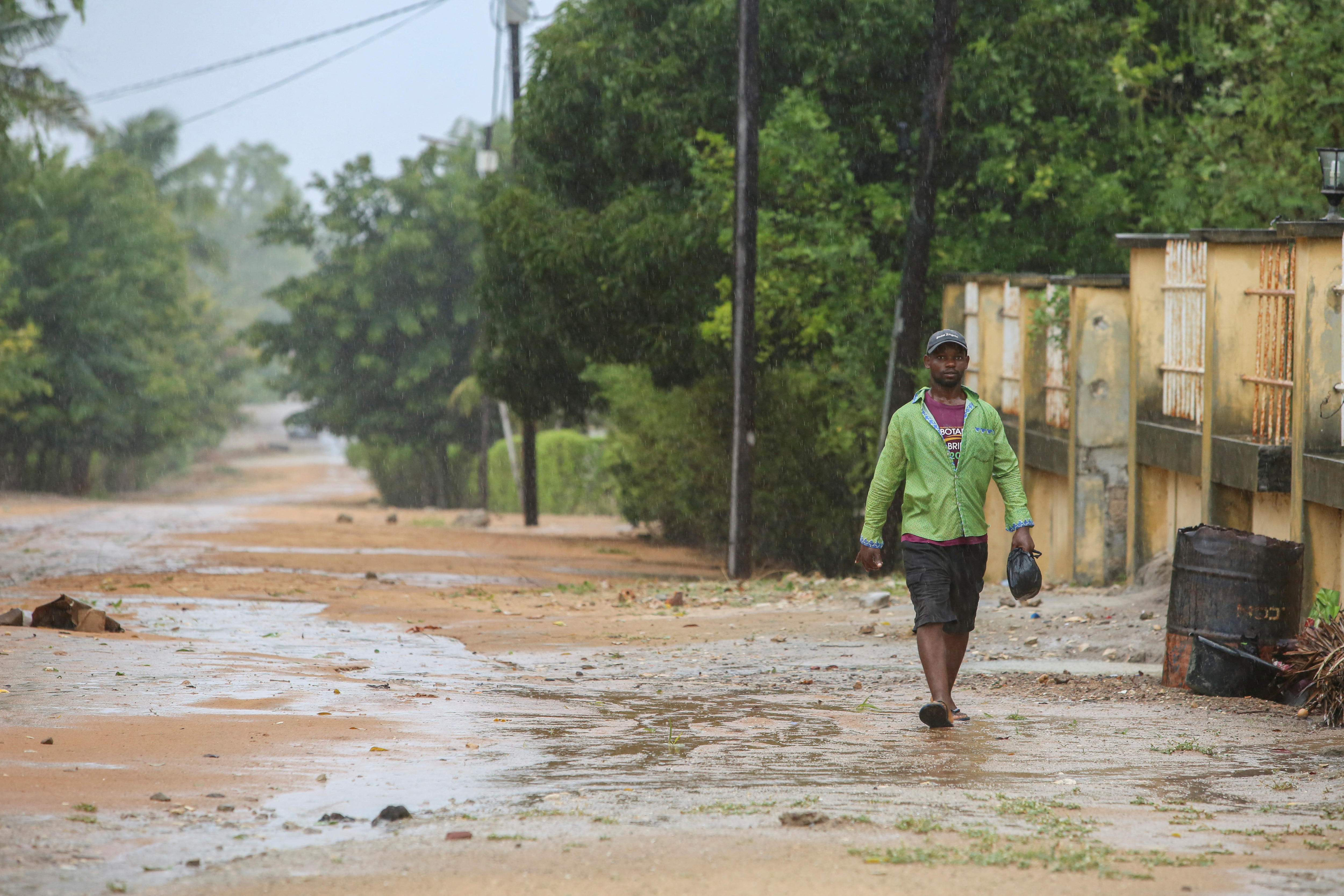 A man walks down a dirt road.