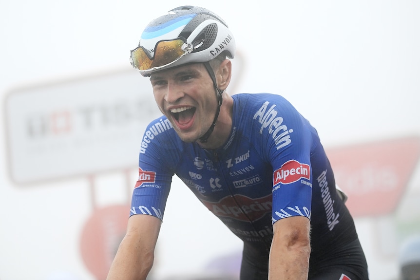 Jay Vine smiles an open-mouthed smile as he crosses the line on stage six of the Vuelta.