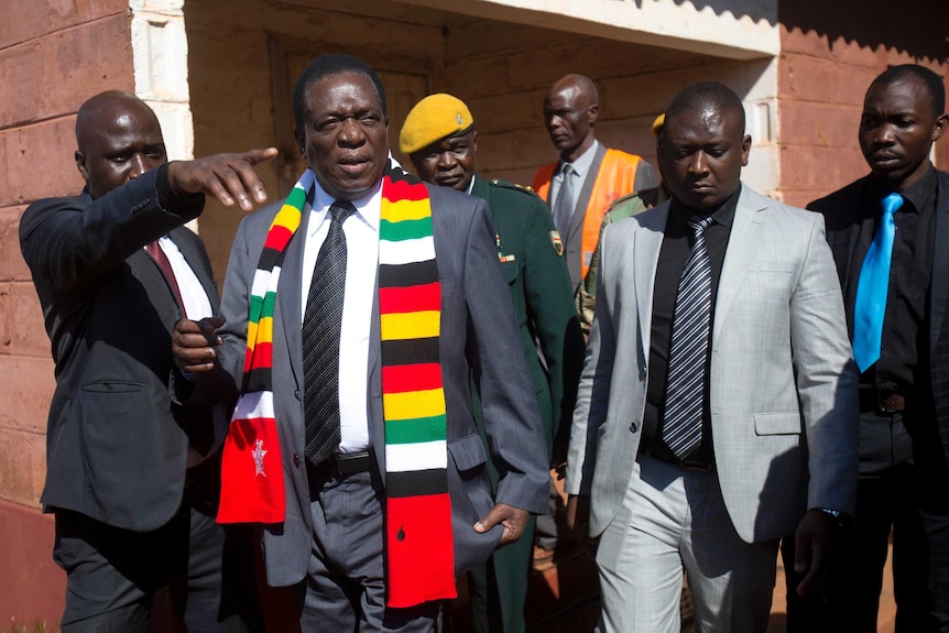 Zimbabwean President Emmerson Mnangagwa leaves the polling station after casting his vote