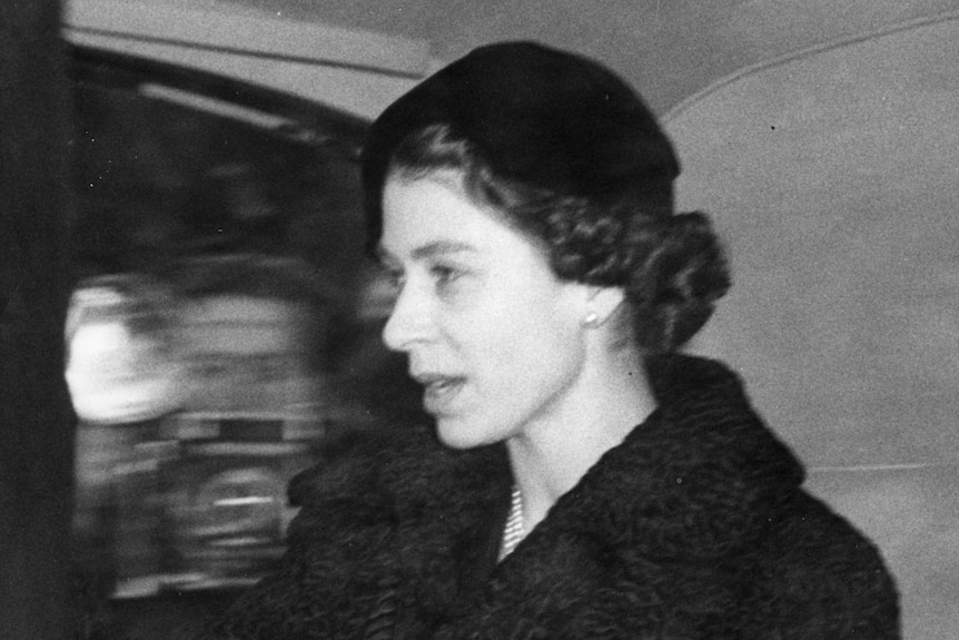 Black-and-white image of the Queen in a car.