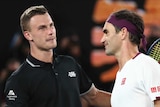 Roger Federer gets a pat on the back from Marton Fucsovics after winning a tennis match